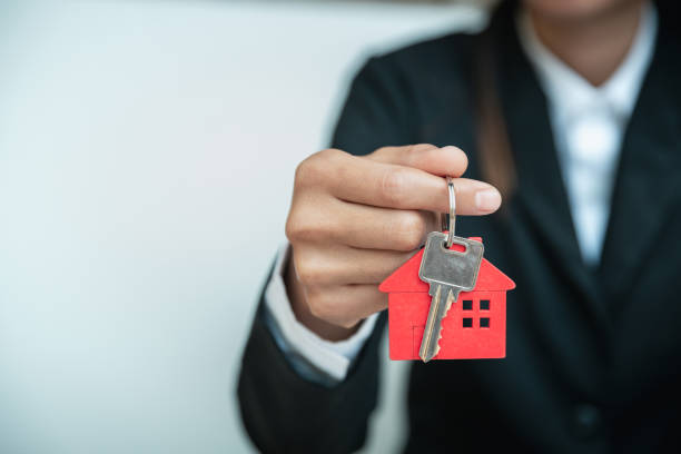 house key in hand, female hand holding house key, real estate agent. - key real estate key ring house key imagens e fotografias de stock