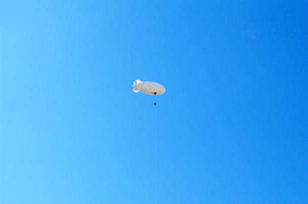 istock Abstract - white blimp airship in the blue sky 1329519491