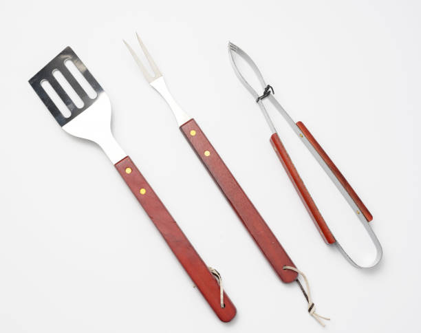 istock tongs, metal spatula and a fork with a wooden handle on a white background 1329519572