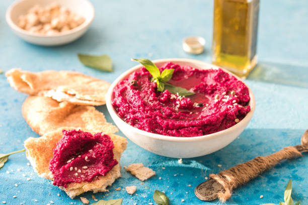 istock Humus Bowl. Red beetroot hummus with flatbread, olive oil on table 1329519590