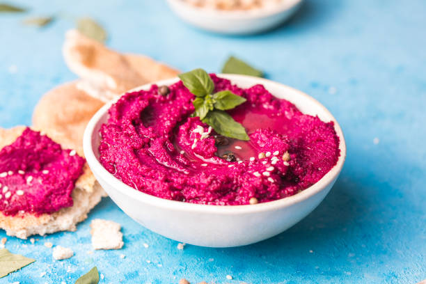 istock Humus Bowl. Red beetroot hummus with flatbread, olive oil on table 1329519594