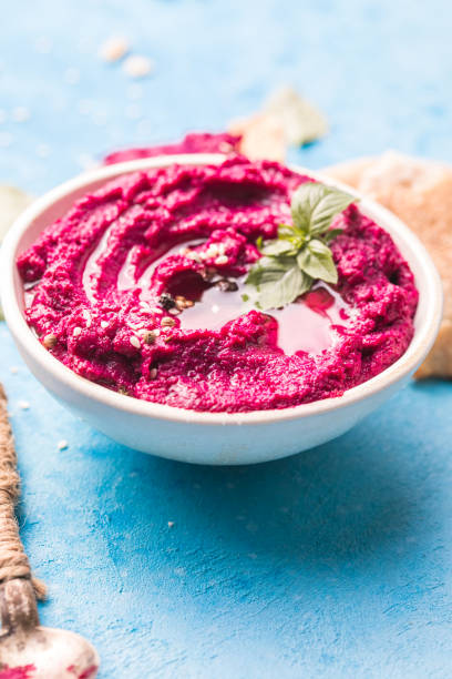 istock Humus Bowl. Red beetroot hummus with flatbread, olive oil on table 1329519598