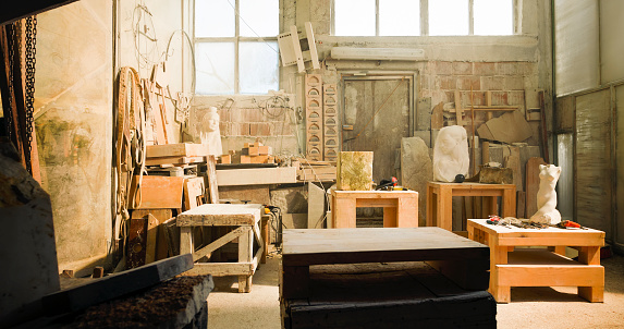 Interior view of stonemason's art studio with bust and pieces of raw stone.