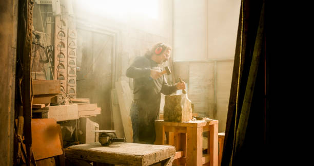 istock Stonemason chiselling a block of stone in workshop 1329520138