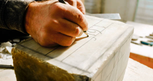 istock Stonemason drawing numbers on block of stone 1329520208