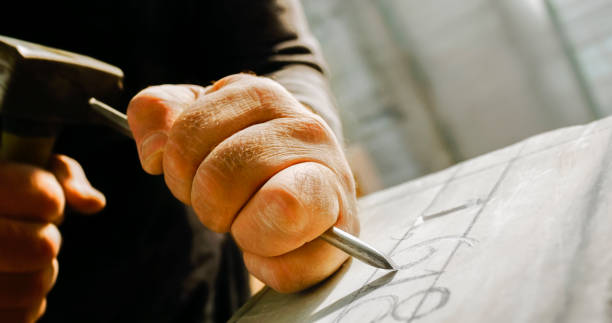 stonemason chiselling numeri su pietra - carved letters foto e immagini stock