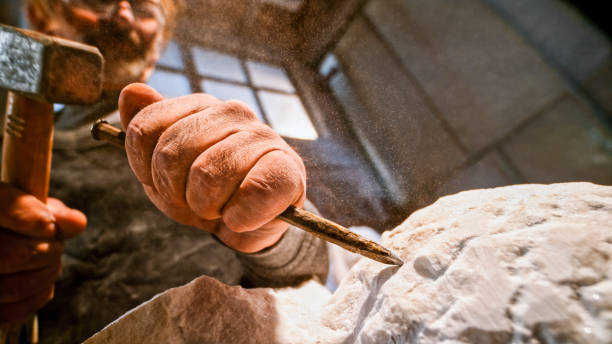 istock Stonemason chiselling surface of white stone 1329520376