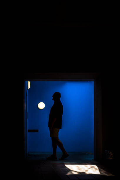 istock A man stands in a blue hallway. 1329521033