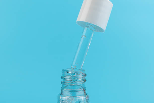 istock face serum drop with bottle on blue background. 1329521620