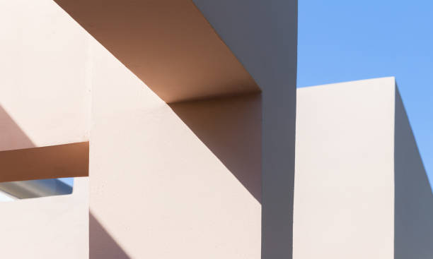 Abstract contemporary architecture photo background, niches in pink painted concrete walls are under blue sky