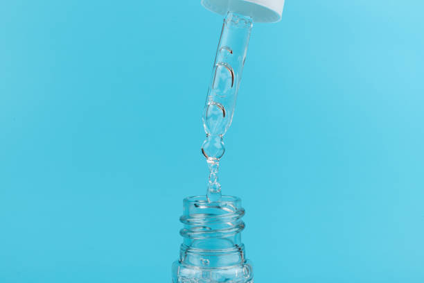 istock face serum drop with bottle on blue background. 1329521752