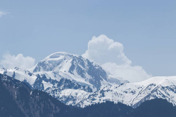 вид на снежную горную вершину, за которой следуют белые облака - kazakhstan glacier snow mountain view стоковые фото и изображения