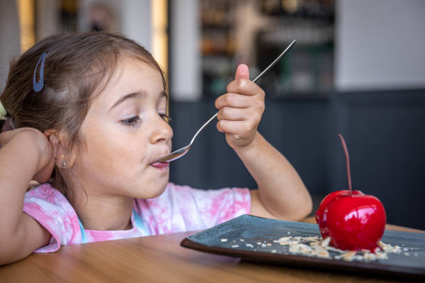 istock A little girl eats a cherry-shaped chocolate mousse, an unusual cherry cake. 1329524327