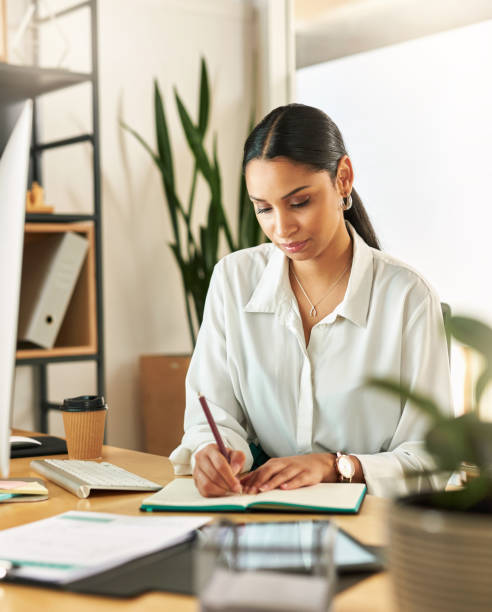istock Shot of a young businesswoman compiling notes at work 1329525921