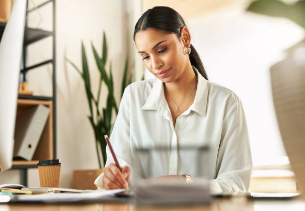 istock Shot of a young businesswoman compiling notes at work 1329525924