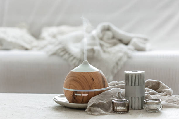 istock Cozy home composition with air humidifier and candles on blurred background. 1329526135