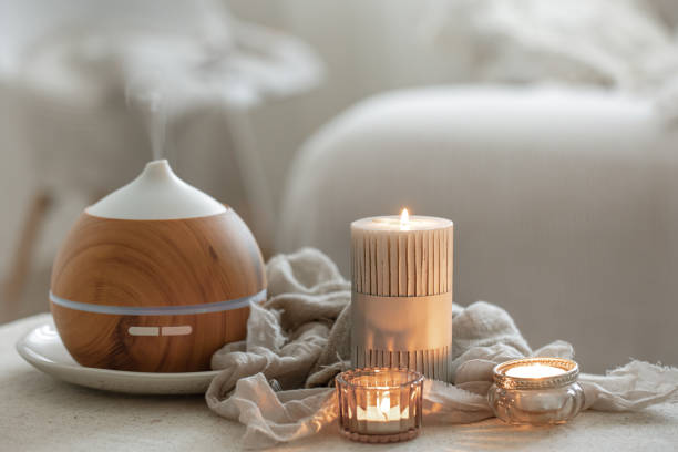 istock Cozy home composition with air humidifier and candles on blurred background. 1329526143