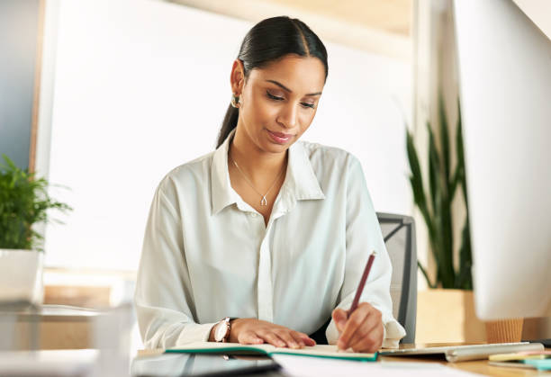 istock Shot of a young businesswoman compiling notes at work 1329526186