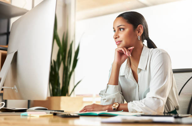 istock Shot of a young businesswoman using her desktop PC at work 1329527095