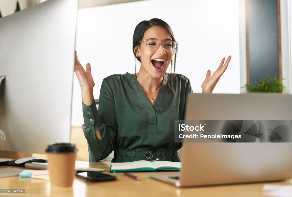Shot of a young businesswoman cheering during a video conference at work Wow thats the best news Excitement Stock Photo