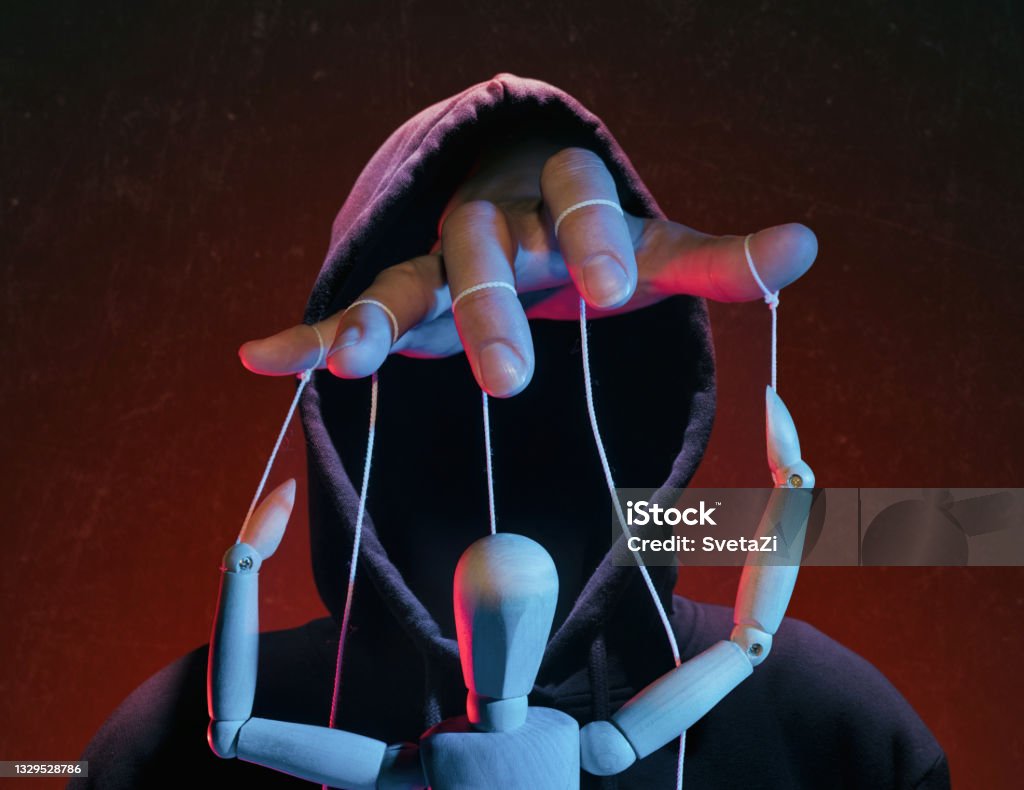 The concept of extortion, blackmail. The concept of extortion, blackmail. Man in a hoodie and a puppet. Conspiracy Stock Photo