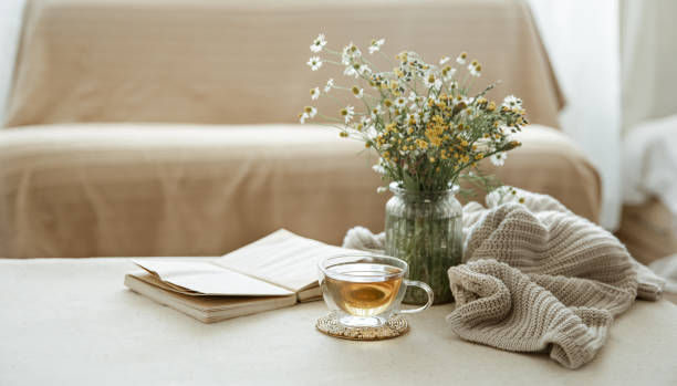 istock Cozy home composition with a cup of tea, a book and flowers copy space. 1329530165