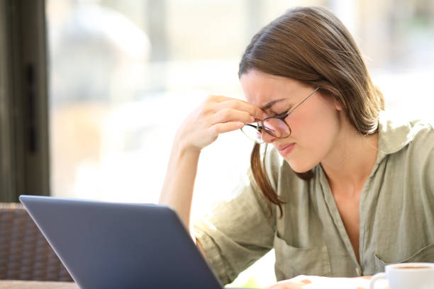 istock Tired woman suffering eyestrain using laptop in a bar 1329533316