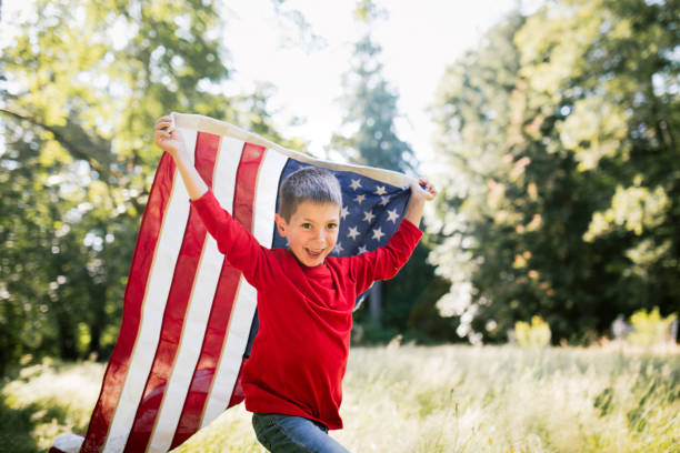 istock Boy In Field With American Flag 1329535608