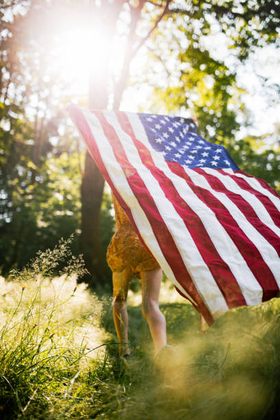 istock Girl In Field With American Flag 1329535610