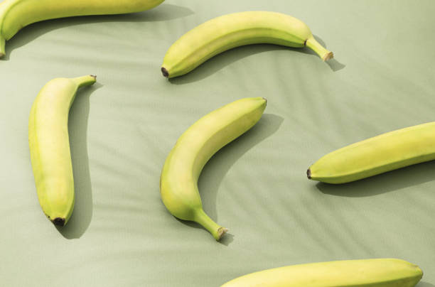 istock Six bananas lie on a green background. Top view 1329537100