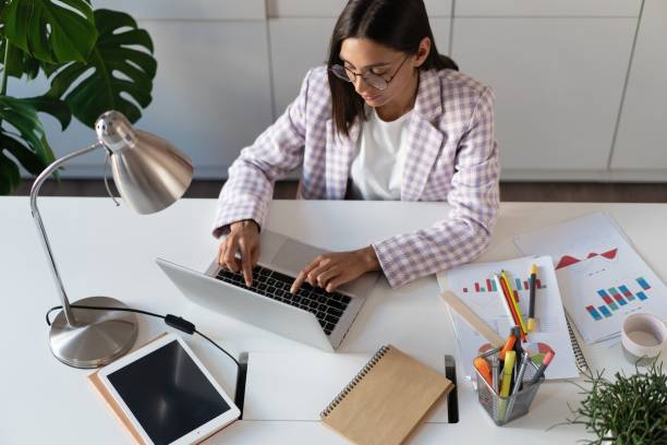 istock Happy young indian mixed-race business woman using computer looking at screen working in internet sit at office desk 1329537145