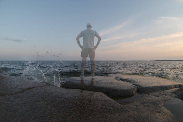 istock A transparent person stands on the seashore. Back view 1329537156