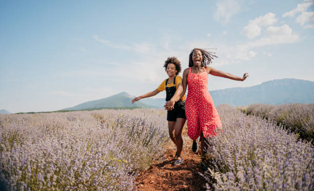 giornata di sole estivo. madre e figlia si divertono con l'aquilone sul campo - spring child field running foto e immagini stock