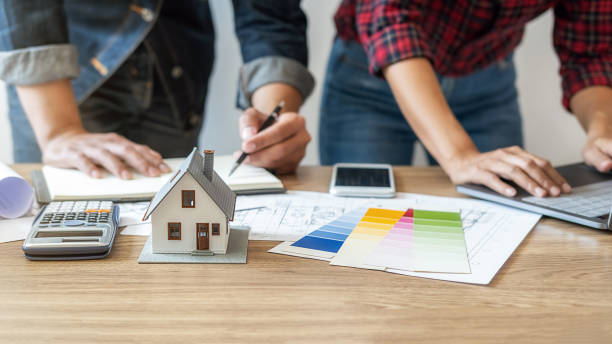 istock Interior designer and Architect choosing color in color swatch samples chart for house coloring selection in office with blueprint. Construction concept. 1329538787