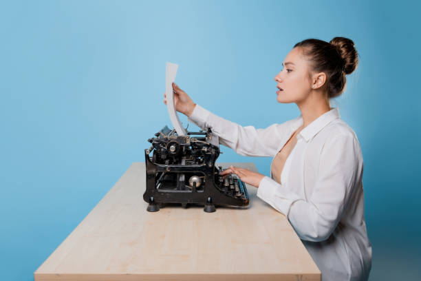 istock young woman author at a typewriter, writes a text. A writer at a table with a vintage typewriter 1329539532