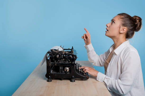 istock young woman author at a typewriter, writes a text. A writer at a table with a vintage typewriter 1329539547