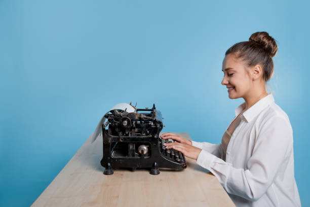 istock young woman author at a typewriter, writes a text. A writer at a table with a vintage typewriter 1329539550