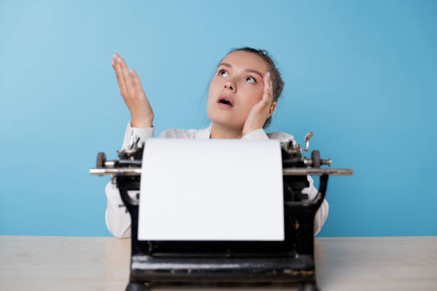 istock young woman writer at a typewriter is bored and can't start writing 1329539578