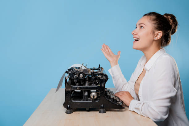 istock happy young woman is an author at a typewriter, is inspired, 1329539602