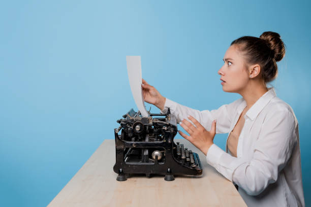 istock young woman writer at a typewriter is shocked by what she wrote, 1329539608