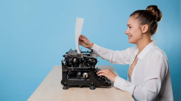istock happy young woman is an author at a typewriter, is inspired, 1329539613