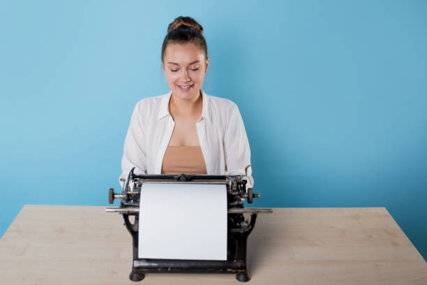 istock happy young woman is an author at a typewriter, is inspired, 1329539622