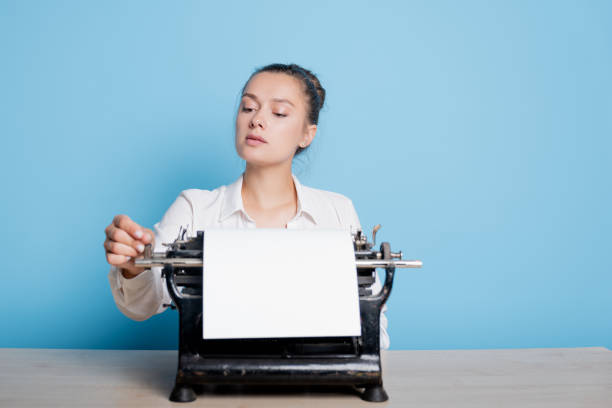 istock young woman author at a typewriter, writes a text. A writer at a table with a vintage typewriter 1329539627