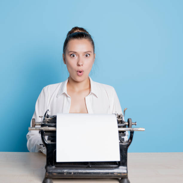 istock young woman writer at a typewriter is surprised, 1329539638