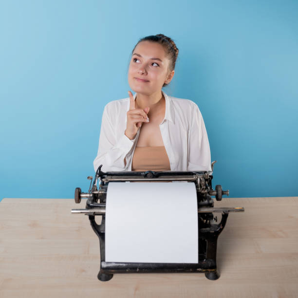 istock happy young woman is an author at a typewriter, is inspired, 1329539647