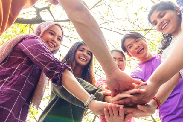 diversi team di adulti sono in cerchio con le mani in un huddle - malesia foto e immagini stock