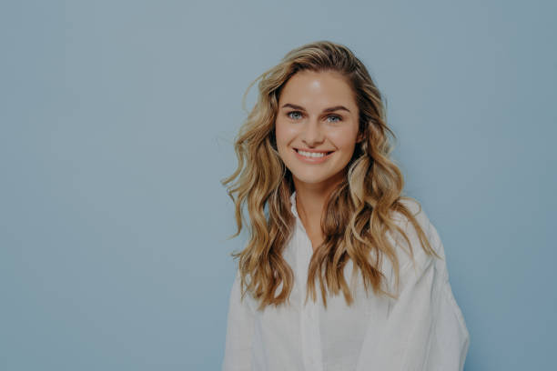 istock Happy blonde woman standing in studio and miling with wide smile 1329540121