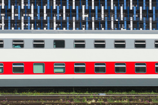 Double-decker passenger train carriage near the train station, side view. Travel concept