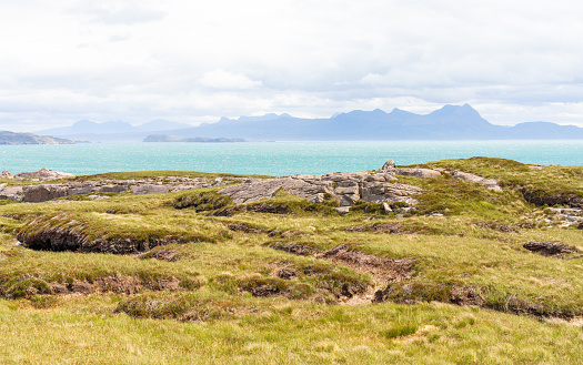 A view of the landscape of Wester Ross in the far north west of Scotland, with peat hags in the foreground.