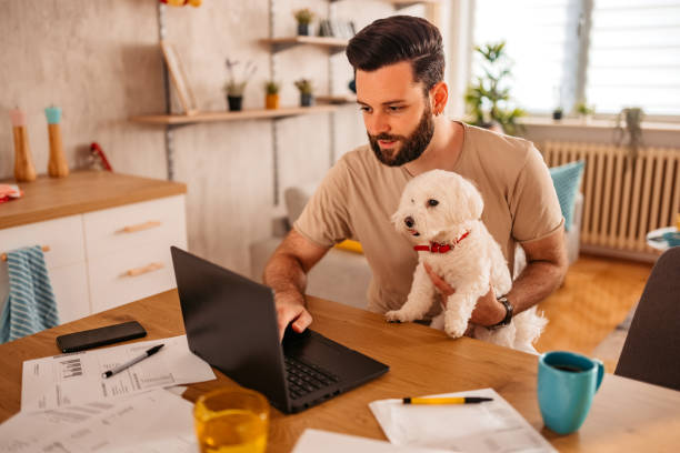 istock Man working on laptop at home with dog in his lap 1329541969